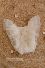 newborn romper in cream on a jute carpet